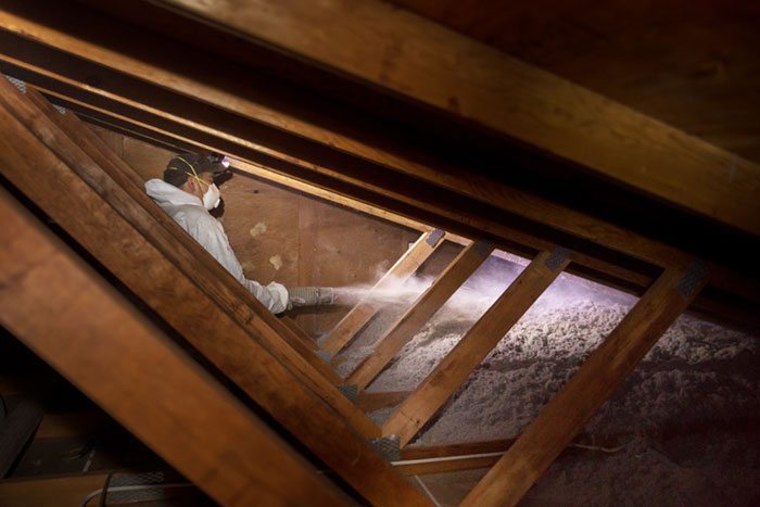 Crawl Pros professional installing new attic insulation material to help with heating bill cost