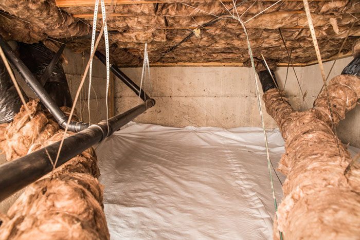 Crawl space and pipes outfitted with insulation and encapsulation to protect the home and space