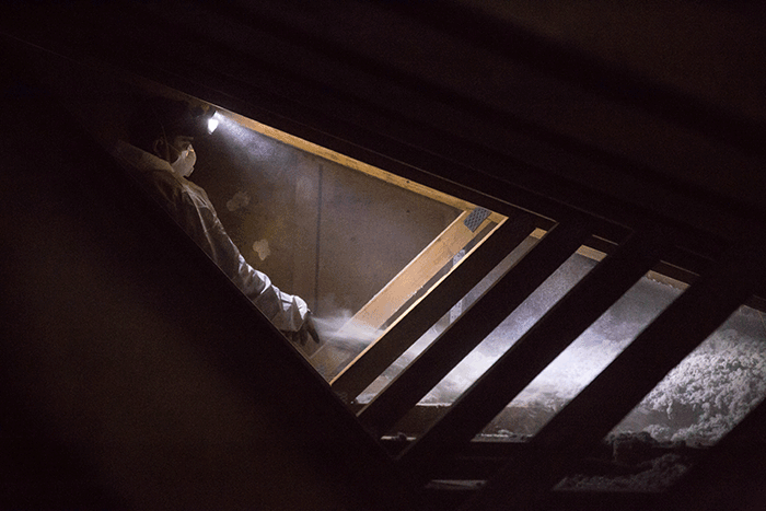 Crawl Pros professional blowing new insulation material into an attic
