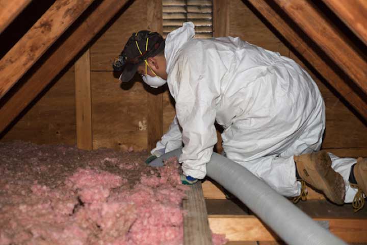 Crawl Pros professional removing old insulation material in a crawl space