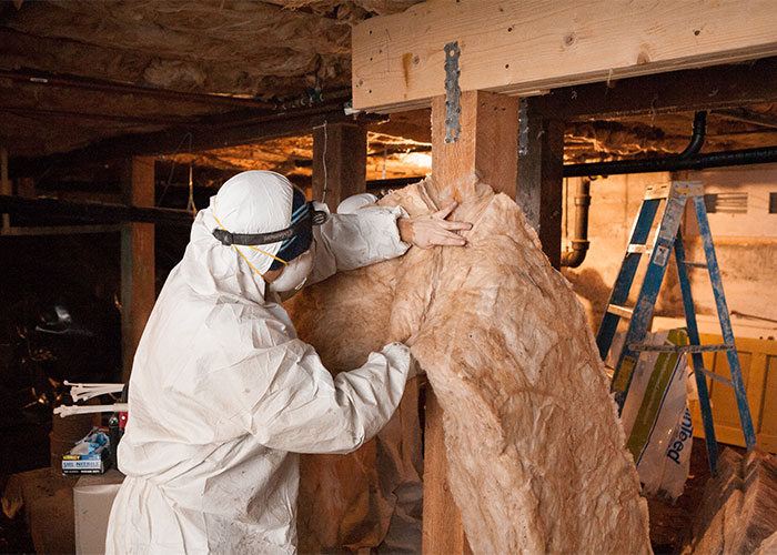 Crawl Pros professional installing new insulation in a crawl space