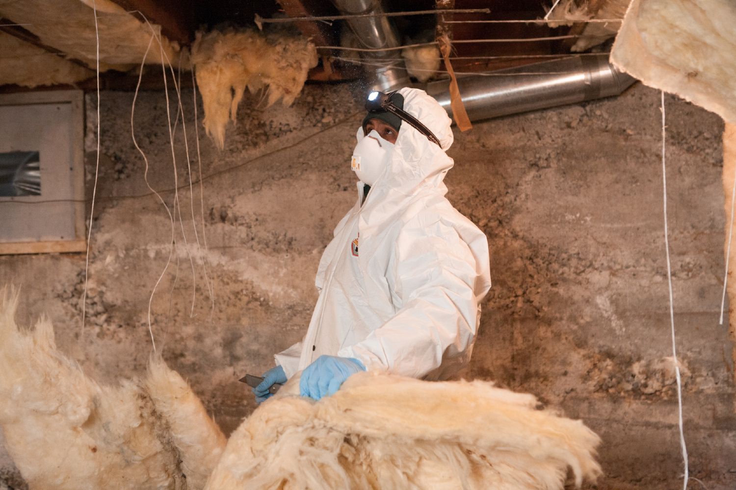 Crawl Pros professional installing new insulation material in a crawl space in Bellevue