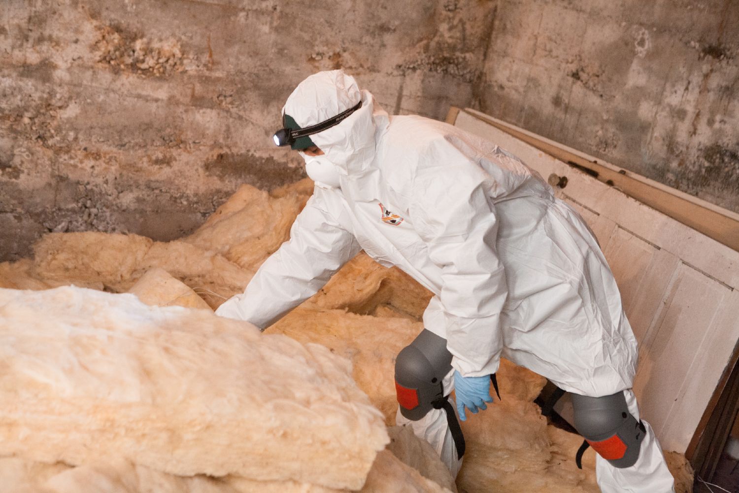 Crawl Pros professional installing new insulation material in a crawl space in Woodinville