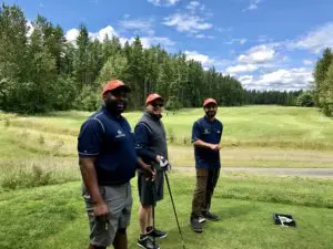 Crawl Pros employees posing for a picture on a tee box at a golf course