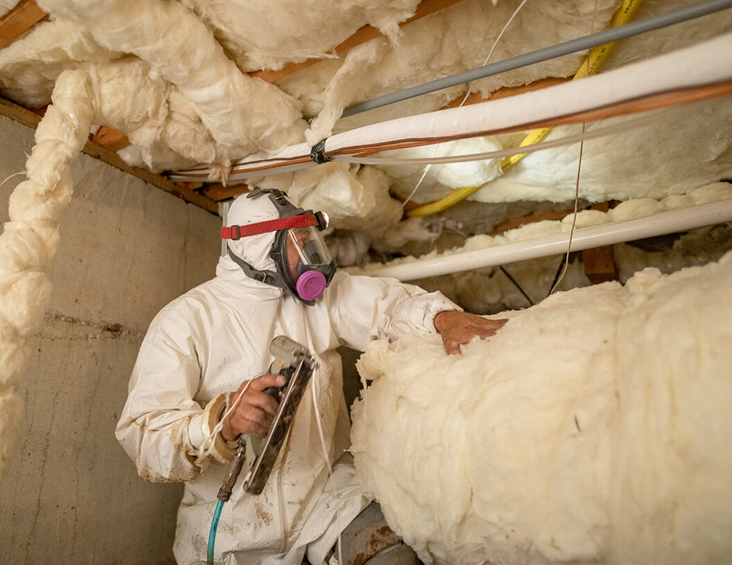 Crawl Pros professional installing new insulation in a crawlspace